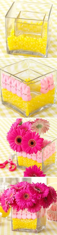 three glass containers filled with flowers on top of a yellow and white striped tablecloth