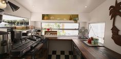 a kitchen with black and white checkered flooring next to an open door window