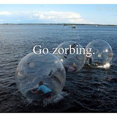 two people in large clear balls floating on water with the words go zorbing