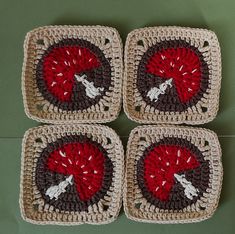 four square crocheted coasters with red and brown designs on them sitting on a green surface