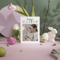 an easter card with a photo of a woman holding a baby in front of some eggs and tulips