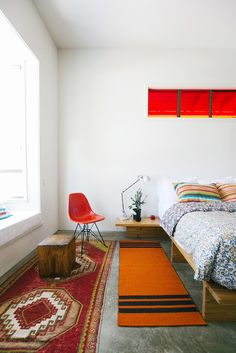 a bed room with a neatly made bed and a rug