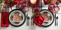 the table is set for christmas dinner with red napkins and place settings on it