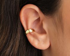 a woman's ear with a gold ring on it