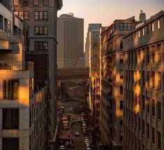 an aerial view of a city street with tall buildings and cars parked on the side