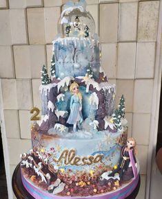 there is a cake that has been decorated with frozen princesses and snowflakes