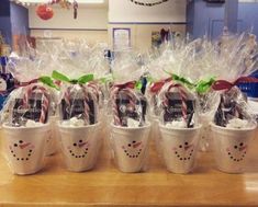 several plastic cups with candy canes wrapped in cellophane and bows on them