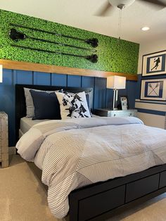 a bedroom decorated in blue and white with green grass on the wall above the bed