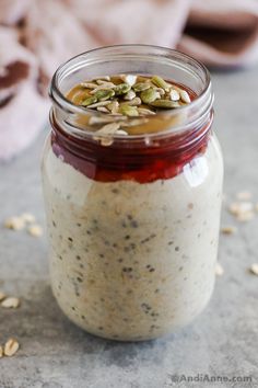 a jar filled with oatmeal and nuts on top of a gray surface