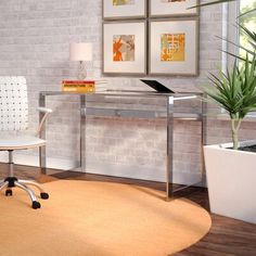 a white chair sitting in front of a desk next to a potted plant