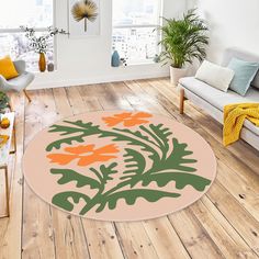 an orange and green rug in the middle of a living room with couches, windows, and potted plants