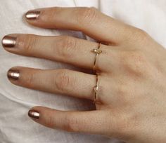 a woman's hand with two gold rings on it