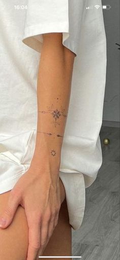 a person with a small tattoo on their left arm and the other hand behind her back