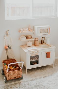 a kitchen with a white stove top oven sitting next to a basket filled with food