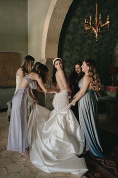 a group of women standing next to each other in front of a chandelier