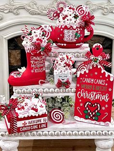 christmas decorations on display in front of a fire place with stockings and candy canes