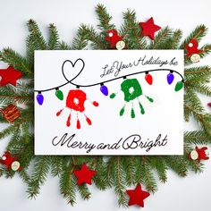 a christmas card with handprints hanging from a string and red stars around it