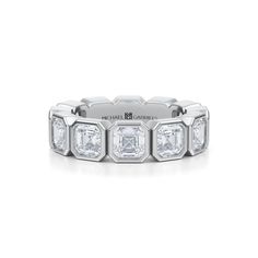 a white gold ring with three princess cut diamonds on the sides and four baguetts in