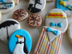 decorated cookies are arranged on a table with an image of a penguin and other items