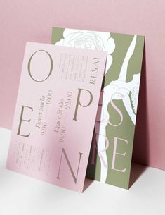 two folded pink and green wedding cards on top of each other with the word open