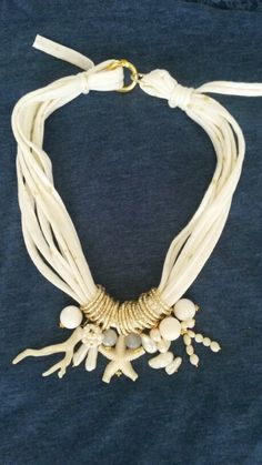 a white necklace with shells and beads on it