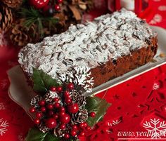 there is a piece of cake on the plate next to christmas decorations and pine cones