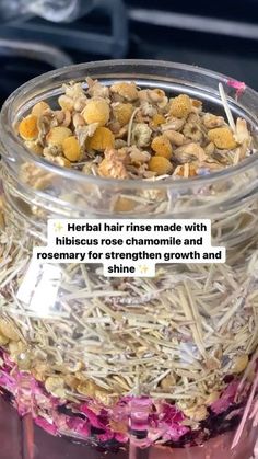 a jar filled with lots of different types of flowers next to a sign that says, herb hair rinse made with hibiscus rose chamomile and rosemary for strength and shine