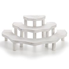 a set of four white benches sitting next to each other in front of a white background