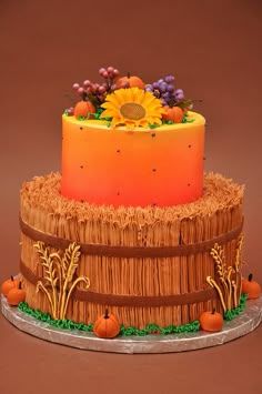 a three tiered cake decorated with sunflowers and pumpkins