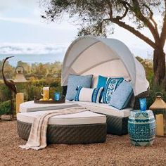 an outdoor bed with blue and white pillows