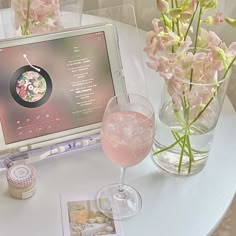 a tablet computer sitting on top of a table next to a vase filled with flowers