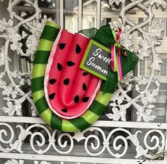 a watermelon wreath on the front door of a house that has been decorated