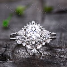 a close up view of a diamond ring on a piece of wood with leaves in the background