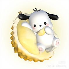 a white and black stuffed animal sitting on top of a yellow shell with its eyes closed