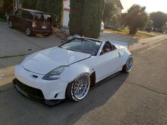 a white sports car parked in front of a house