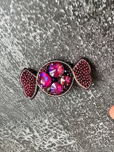 This exquisite handmade brooch in deep burgundy is a true statement piece. It's crafted with love and expertise, using high-quality beads and sparkling crystals to create a unique accessory. The brooch will accentuate your individual style and add charm to any outfit. It's the perfect accessory for special occasions or to add a vibrant touch to everyday wear. Let this brooch elevate your style with sophistication and elegance. Treat yourself or a dear friend to this stunning brooch that will bec Wedding Brooches, Beaded Brooches, Handmade Candy, Wedding Brooch, Deep Burgundy, Beaded Brooch, Brooches Handmade, Sparkling Crystal, Accessories Unique