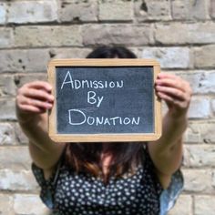 a woman holding up a blackboard with the words adonis by donation written on it