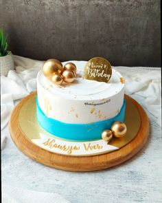 a white and blue cake with gold decorations