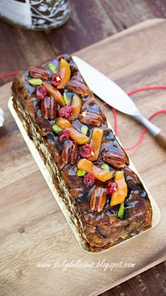 a wooden cutting board topped with a piece of fruit cake