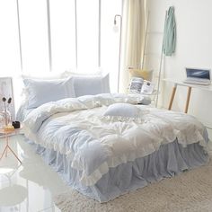 a white bed sitting in a bedroom next to a window with lots of light on it