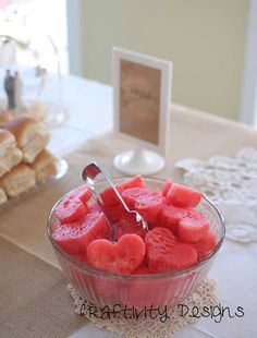 watermelon slices in a glass bowl on a table with other desserts and pastries