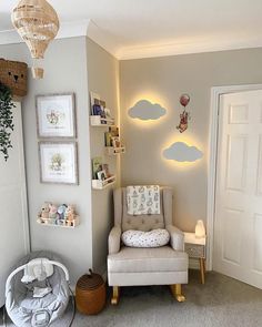 a baby's room with a rocking chair and clouds on the wall