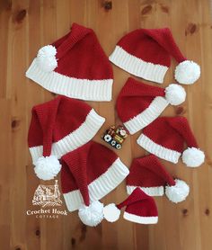 a group of red and white knitted hats on top of a wooden floor