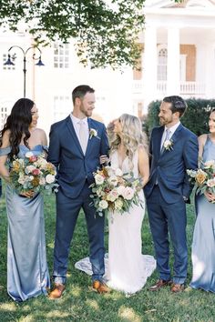 a group of people standing next to each other in front of a building with flowers