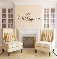 two chairs in front of a fireplace with the name william family on it's wall