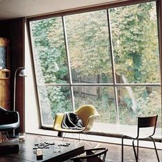 a living room filled with furniture next to a large window covered in lots of windows