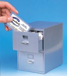 a hand is opening a file cabinet with a ticket in it and another person's hand reaching for the money