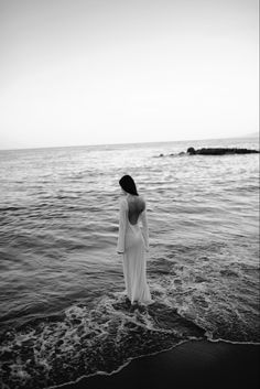 a woman standing in the water at the beach