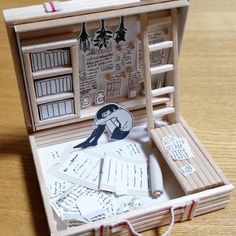 an open wooden box with writing on the inside and papers in it sitting on a table