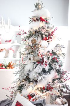 a white christmas tree with red and gold ornaments